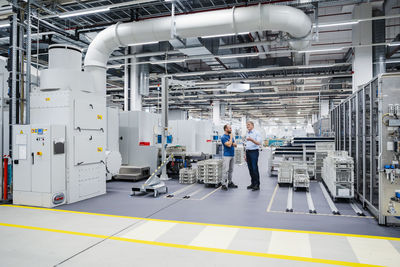 Businessman and employee talking in a factory