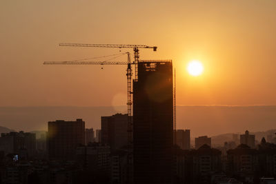 Buildings in city against sky during sunset