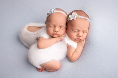 Cute twin babies sleeping on bed