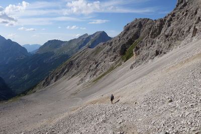 Rear view of person walking on landscape against sky