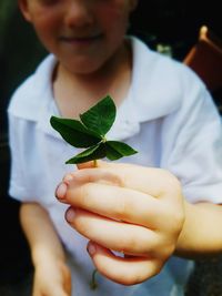 Midsection of boy holding leaves
