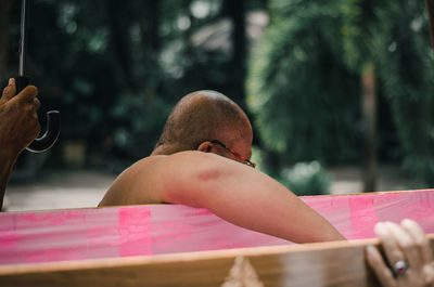 Midsection of man holding mobile phone outdoors