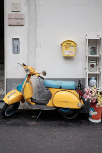 Yellow motor scooter against wall in city