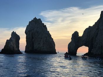 Rock formations in sea against sky