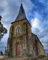 Low angle view of church against cloudy sky