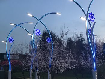 Illuminated decoration hanging on tree against sky