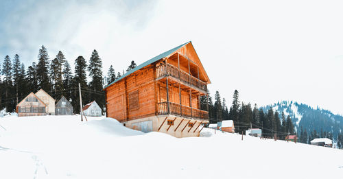 Panoramic view of snow covered buildings against sky