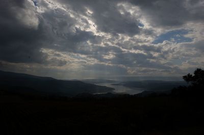 Scenic view of storm clouds over silhouette landscape