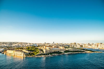 River in city against blue sky