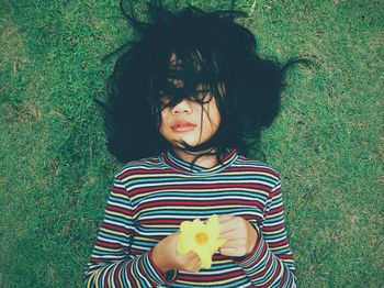 High angle view of woman with messy hair lying on grass