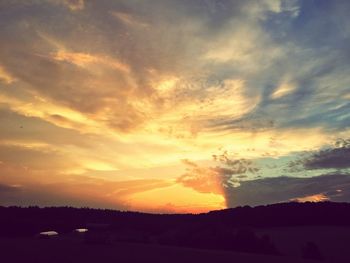 Scenic view of dramatic sky over silhouette landscape