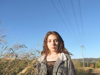 Portrait of a beautiful young woman against blue sky