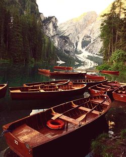 Boats moored by river against mountains