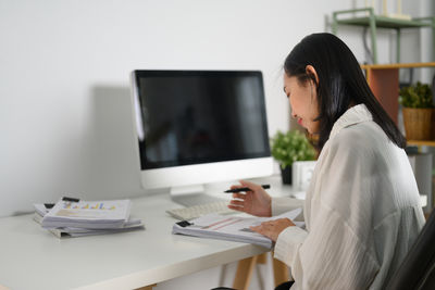 Side view of businesswoman working at office