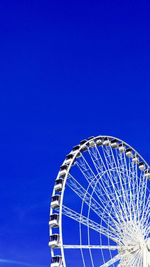 Low angle view of ferris wheel against blue sky