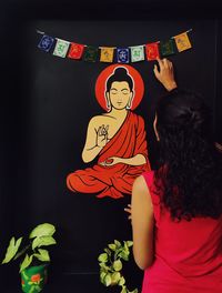 Rear view of woman standing against wall