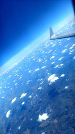 Aerial view of aircraft wing against blue sky