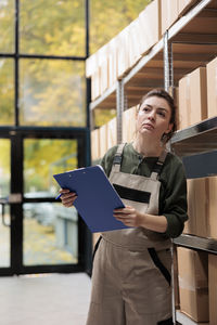 Portrait of young man using digital tablet while standing in city