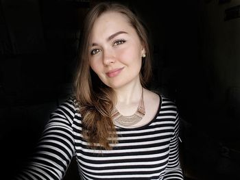 Portrait of smiling beautiful woman in darkroom