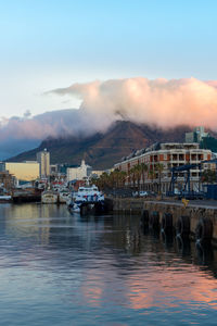 View of boats in lake against cloudy sky