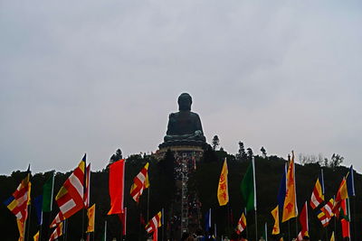 Low angle view of multi colored flags against sky