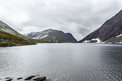 Scenic view of lake by mountains against sky