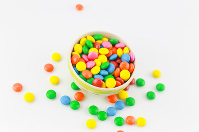 High angle view of multi colored candies against white background