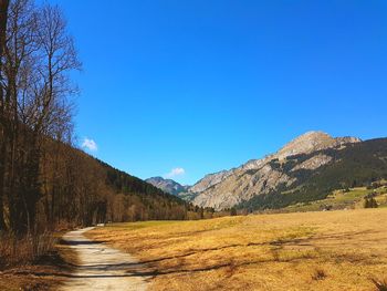 Road amidst landscape against clear blue sky