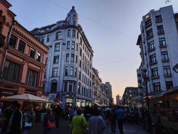 People walking on street amidst buildings in city