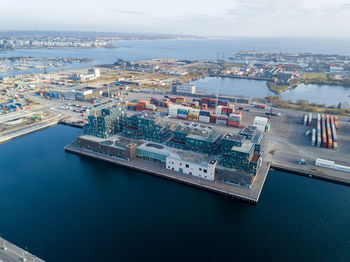 High angle view of city by sea against sky