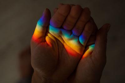 Cropped hand of person gesturing against black background