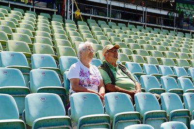 Couple sitting on chairs at auditorium