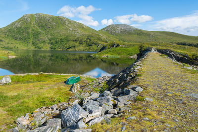 Scenic view of lake by mountains against sky