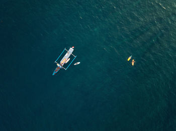 Aerial view of surfers and boat in the ocean, lombok, indonesia