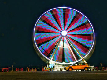 Illuminated ferris wheel at night