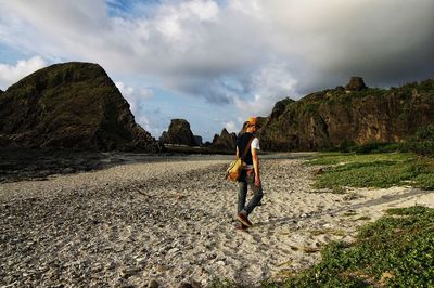 Man walking by rock formations at green island