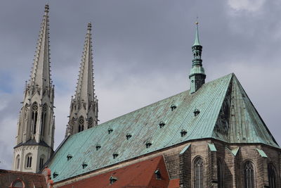 Low angle view of church against cloudy sky