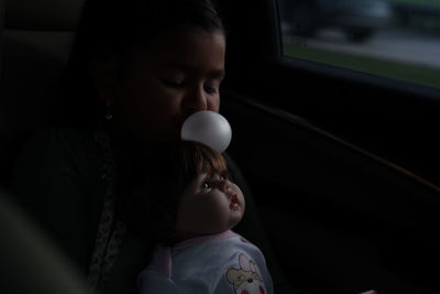 Portrait of cute girl playing with doll 