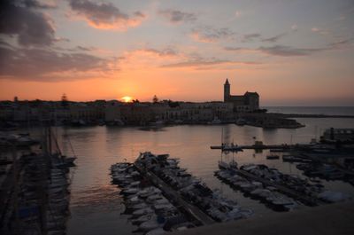 View of buildings at waterfront during sunset