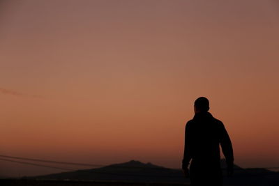 Rear view of man against sky during sunset