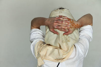 Midsection of woman holding hands against white background