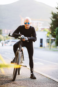 Full length of man with bicycle on road