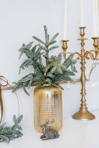 Christmas decor in a classic living room or spruce branches in gold vases with toys