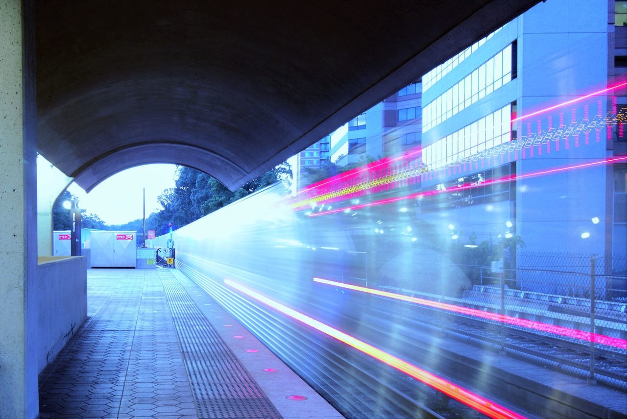 transportation, motion, blurred motion, road, speed, on the move, long exposure, street, city, built structure, car, land vehicle, illuminated, architecture, mode of transport, city life, light trail, bridge - man made structure, building exterior, the way forward, moving, outdoors, tail light, arch, tunnel, public transport, rush hour