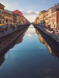 Canal amidst city against sky