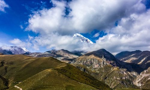 Scenic view of snowcapped mountains against cloudy sky