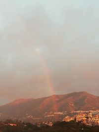 Scenic view of rainbow over city against sky