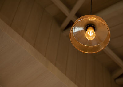 Directly below shot of illuminated light bulb hanging from ceiling