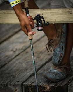 Low section of man fishing while standing on pier