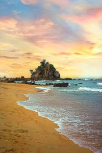 Scenic view of beach against sky during sunset